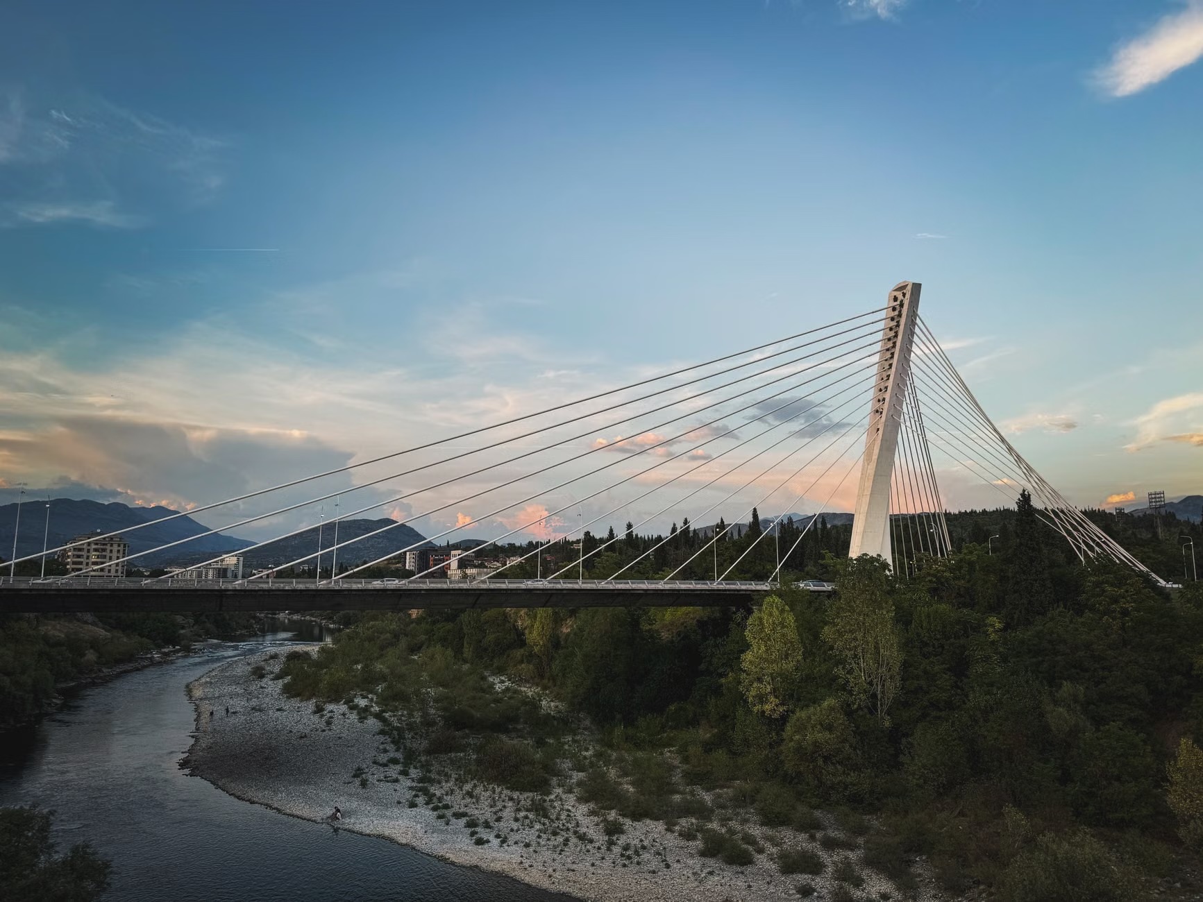 Cable-stayed bridge over a river at dusk, annotated with engineering context pins