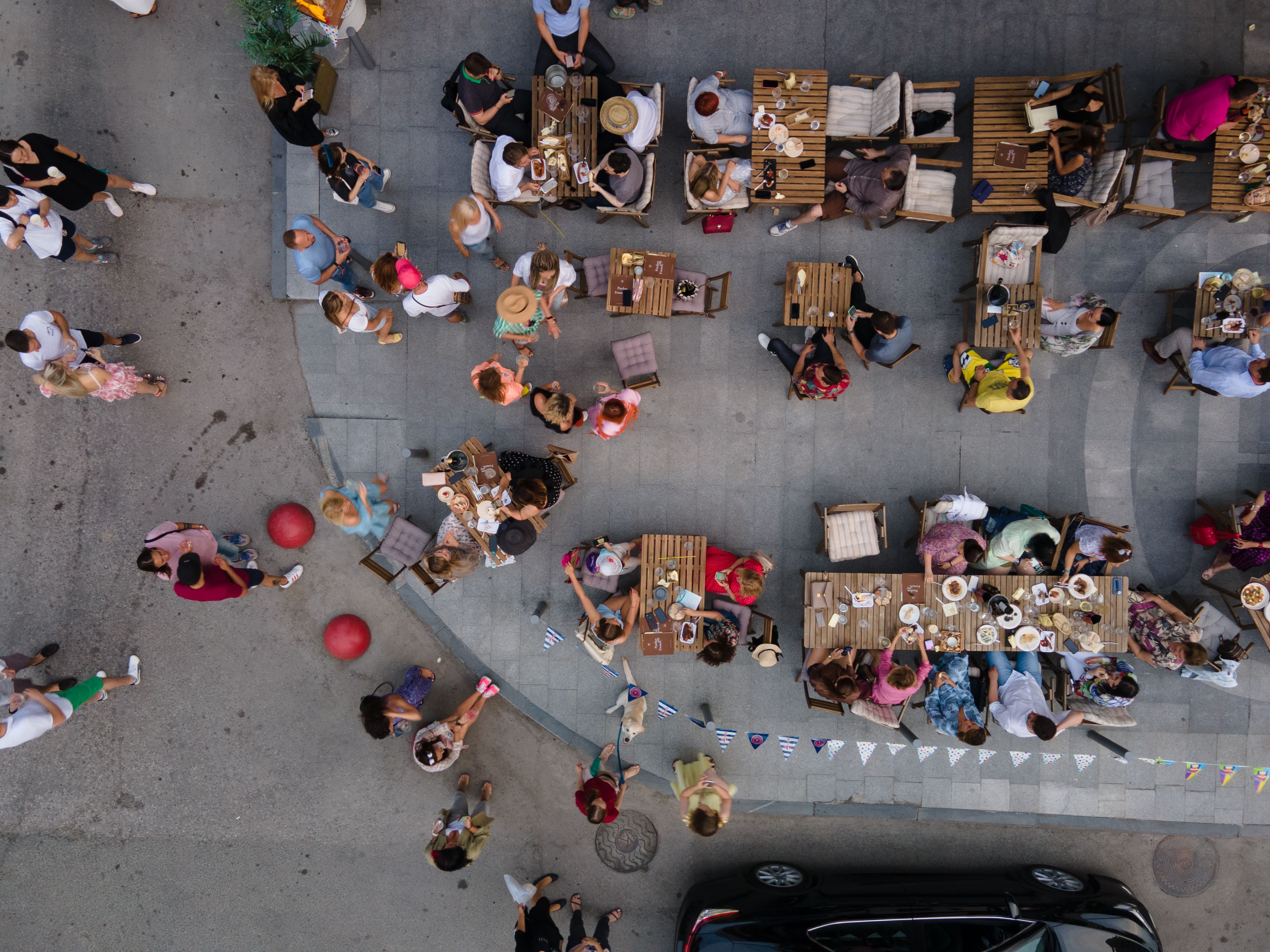 Top-down photograph of a busy outdoor cafe, full of activity, with nothing marked or annotated